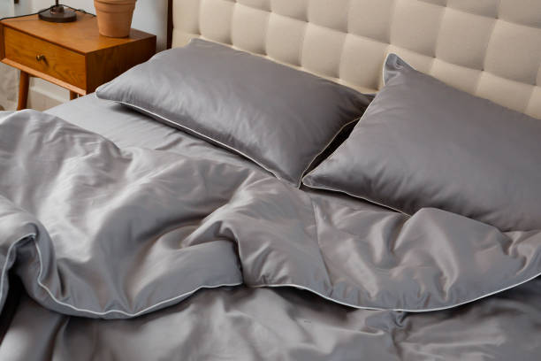 Morning mess on a rumpled gray bed